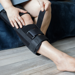 Personal injury victim putting on a leg brace